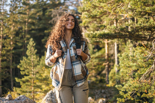 istock Woman hiking with backpack along forest path smiling 2161634916