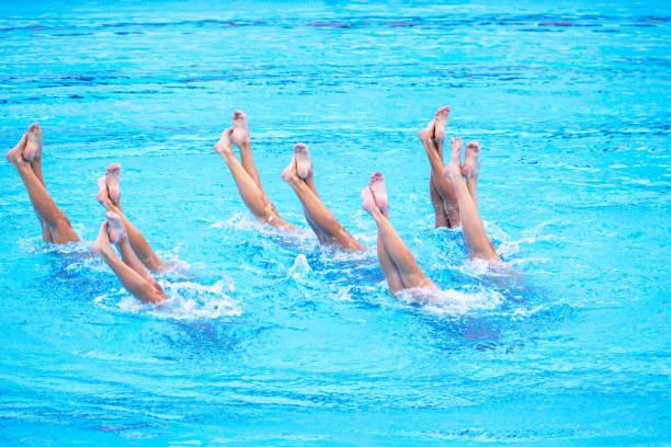 istock Artistic swimming team in swimming pool performing synchronized legs movement 2161635568