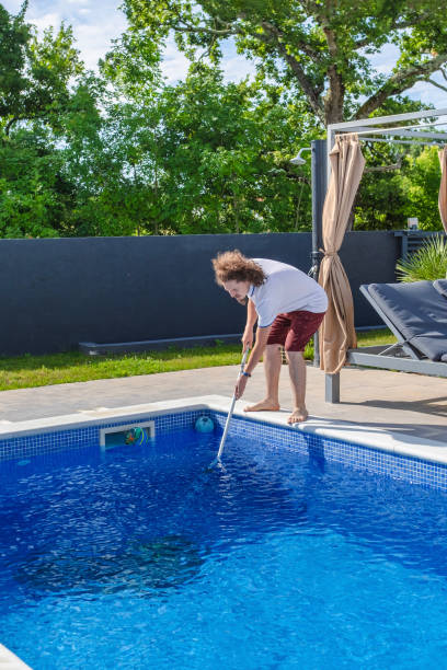 istock Pool boy cleaning the swimming pool 2161637709