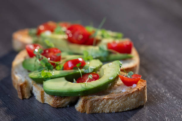 istock avocado toast topped with tomato and sprouts 2161641504