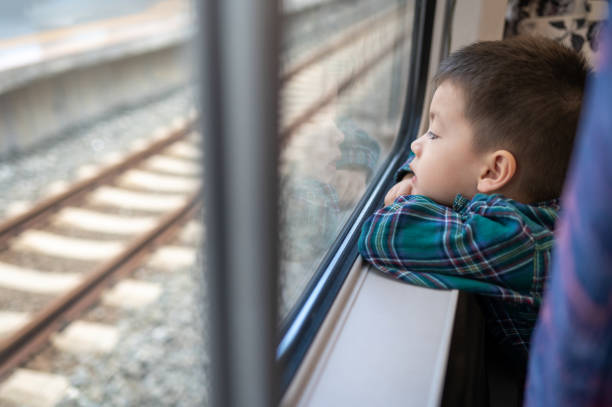 istock Curious Young Boy Riding the Train Looking Out the Window 2161641877