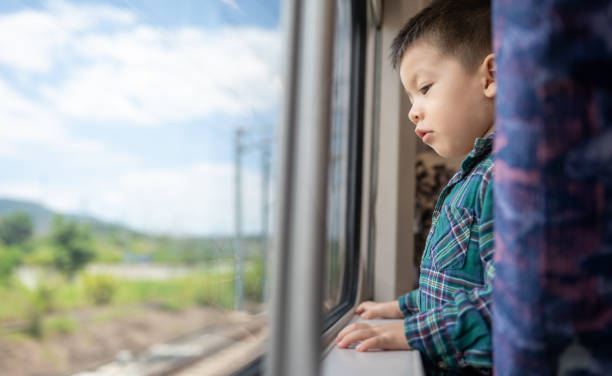 istock Curious Young Boy Riding the Train Looking Out the Window 2161642191