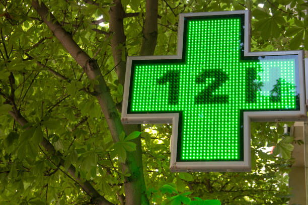 istock Pharmacy indication sign, a luminous green cross that indicates that a pharmacy is open and providing service. 2161650705
