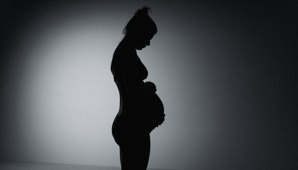 istock Pregnant woman model posing on black background in studio. 2161653462