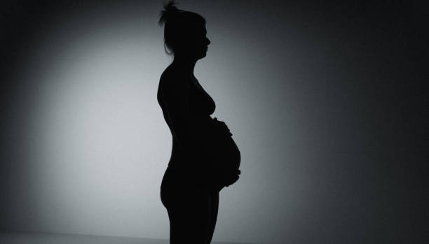 istock Pregnant woman model posing on black background in studio. 2161653469