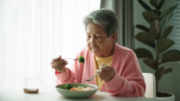 istock Senior woman eating vegetable. 2161658542