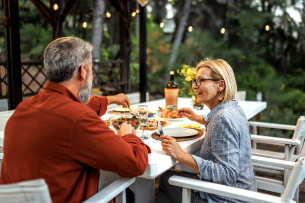 istock Casually clothed mature couple having romantic dinner together at the back yard 2161660623