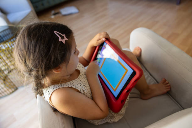 istock a little girl playing with a tablet on the couch 2161660989