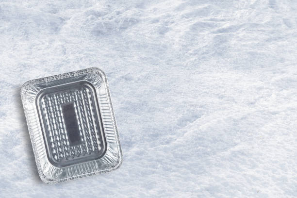 An Empty aluminum disposable tray top view on a snow background