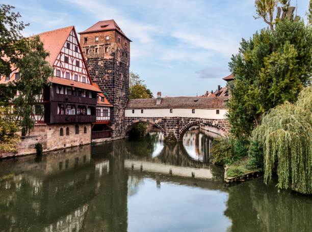 The famous Nuremberg Hangman’s Bridge was built in 1595 when Nuremberg suffered severe damage from a flood. The previous bridge, built in 1457 and part of the city wall, was badly damaged. It was therefore replaced by the wooden bridge with bricks. The unusual name of the Hangman’s Footbridge comes from the neighbouring tower, where the hangman of Nuremberg lived between the 16th and 19th centuries. In the Middle Ages, the hangman entered the city via the Henkersteg. During the Second World War, the wooden footbridge was again badly damaged. It was not until 1954 that it was rebuilt to its original design.