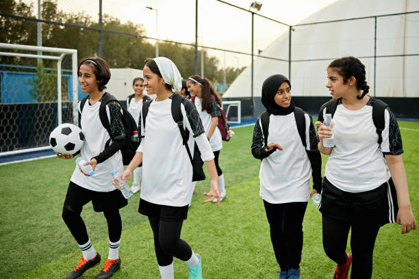 istock Middle eastern female soccer players talking while walking on field 2161667647