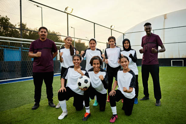 istock Instructors and soccer players cheering together on field 2161668043