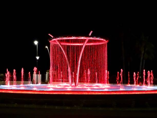 A sparkling red coloured illuminated fountain at night in Estepona in southern Spain