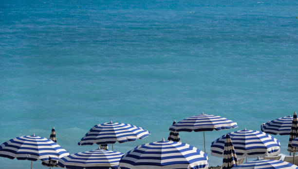 istock Blue and white parasols at the beach 2161670237