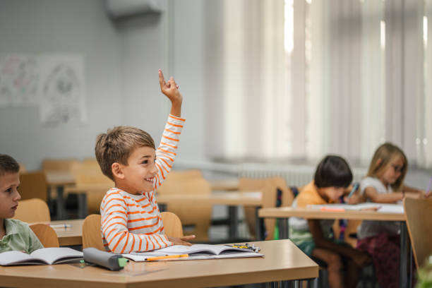 istock Young boy student raise his hand to answer a question during a lesson 2161672064