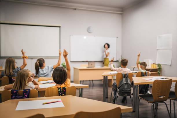 istock Young students raise his hands to answer a question during a lesson 2161673434