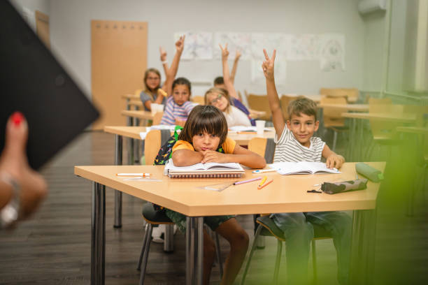 istock Young students raise his hands to answer a question during a lesson 2161673482