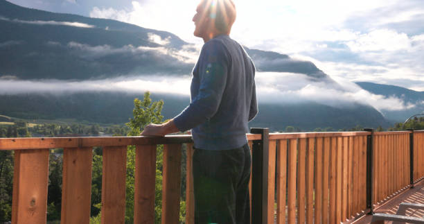 istock Senior man looks at mountains from verandah 2161682154