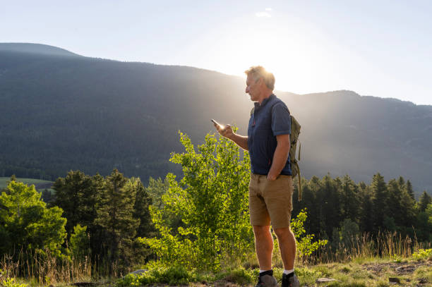 istock Senior man uses mobile phone in meadow 2161684853