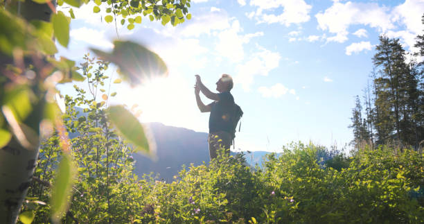 istock Senior man uses mobile phone in meadow 2161685579