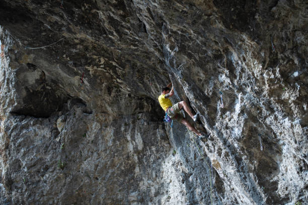 istock Determined climber climbing up a steep rock cave. 2161685790