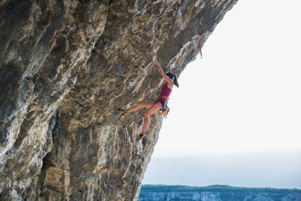 Shot of professional female climber climbin a steep cliff.