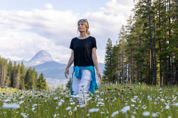 Young woman hikes in mountain meadow