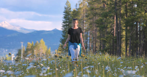 Young woman hikes in mountain meadow