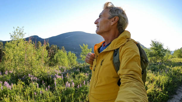 Senior man hikes pathway in mountains
