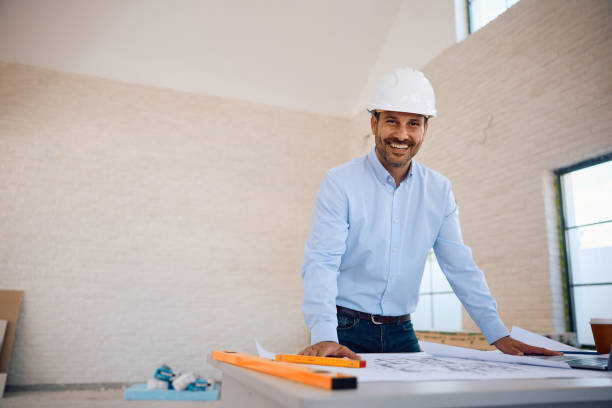 istock Happy architect working on housing plans and looking at camera. 2161686618