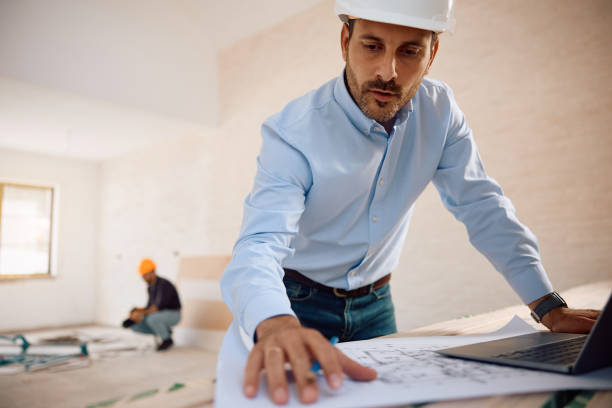 istock Housing project manager examining blueprints at construction site. 2161686851