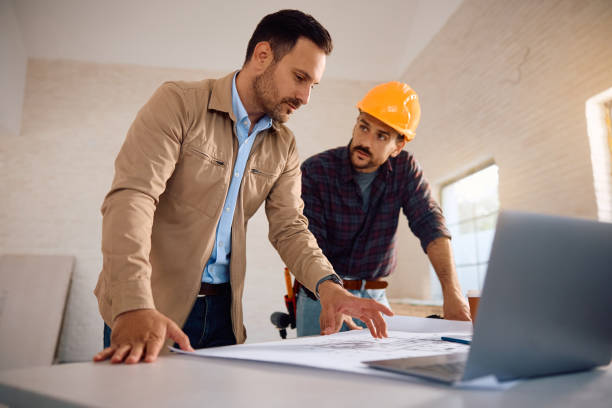 istock Mid adult man and construction worker examining housing plans during home remodeling process. 2161686900