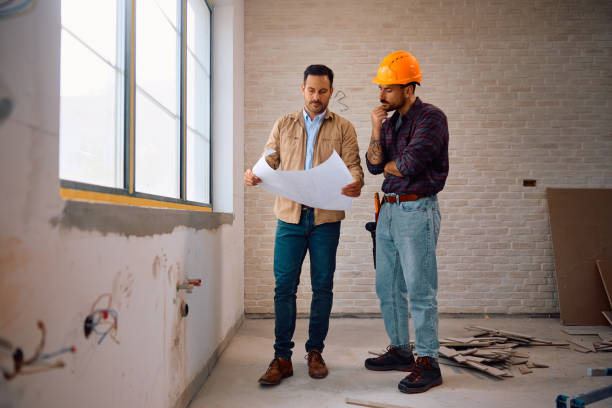 istock Home owner and construction worker examining blueprints during renovating process. 2161686931