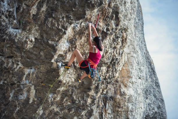 istock Woman is climbing a very steep rock cave. 2161690184