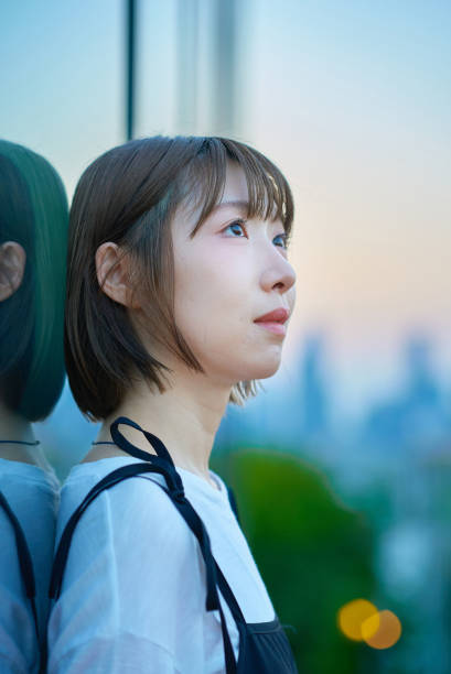 istock a young woman standing in the city during magic hour 2161693390