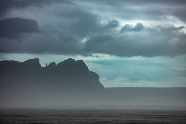 Snow capped peaks rise out of the clouds in Iceland's mountainous southern region
