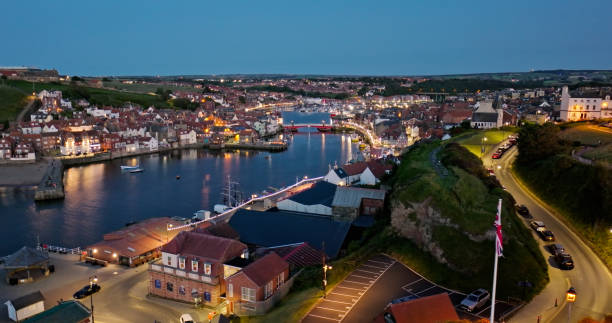 Aerial shot of Whitby, a town on the North Yorkshire coast in England famous for its ruined abbey, at twilight on a summer evening.