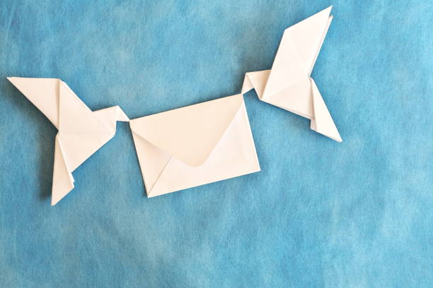 istock Two white dove carrying white envelope in blue background. Wedding invitation and message of peace concept. 2161699900