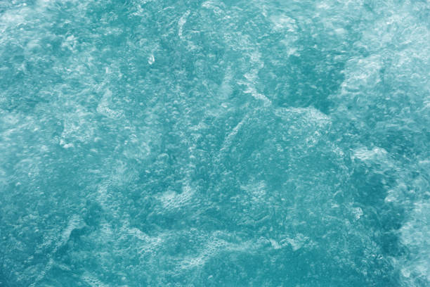 Bubbling water texture, flow thermal water as abstract background macro photo, spa and wellness theme, gentle ripples and gurgling on white turquoise aquatic surface, sea monochrome color gradient