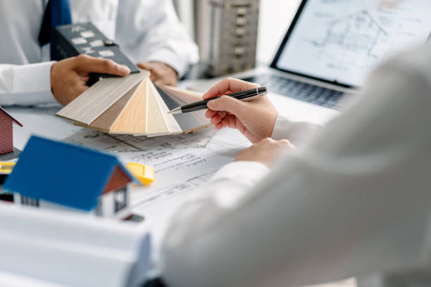 istock Team architects select palette color for modern house model and house plans a blueprint in the office, development low residence projects, design home custom of customer, build a housing estate. 2161705577