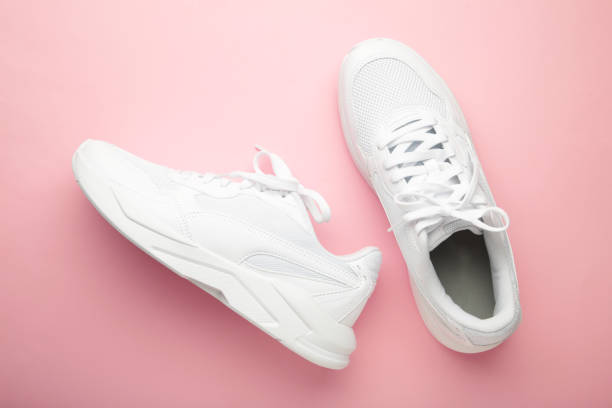 istock White sneakers on a pink background. Space for text 2161711111