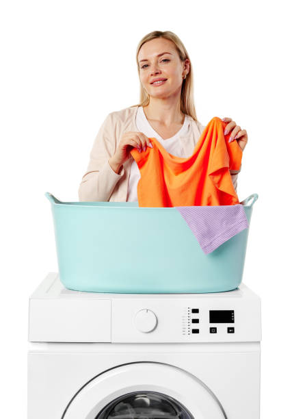 Woman Holding White Laundry Over a Washing Machine on white background close up