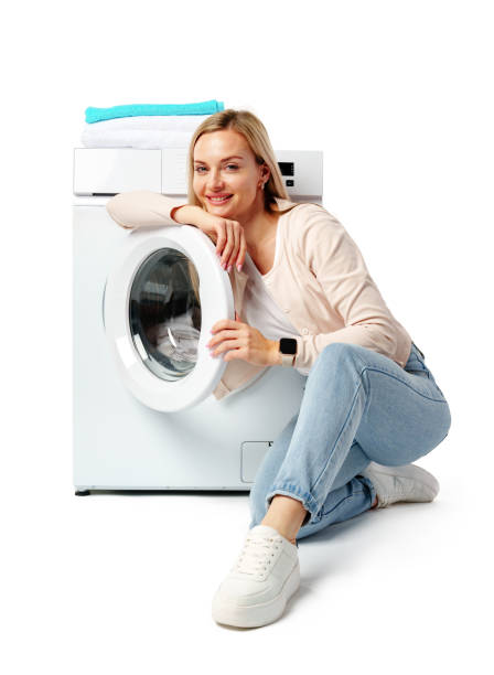 istock Young Woman Posing with White Washing Machine in a Studio 2161712648
