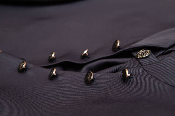 Close-up of a buttoned suit jacket with an intricate design, showcasing the craftsmanship and attention to detail