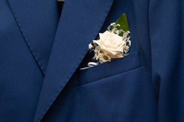 istock Groom wearing blue suit with white rose boutonniere getting ready for wedding 2161714946