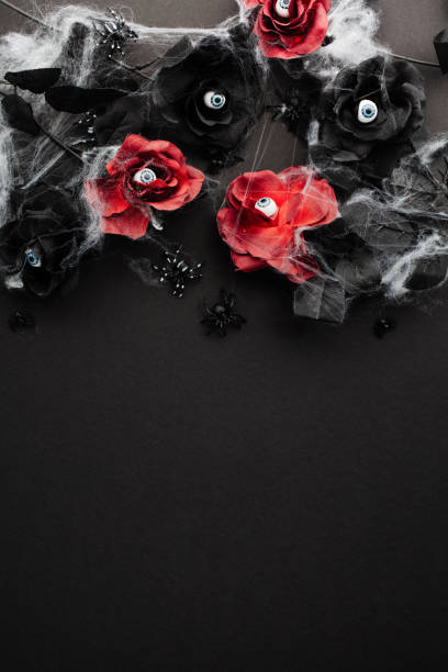 istock Gothic Halloween vertical background with red and black roses decorated eyeballs, spiders with web on dark table. Flat lay, top view. 2161719049