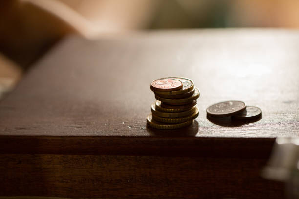 istock Stack of euro coins balancing on wooden desk 2161719735