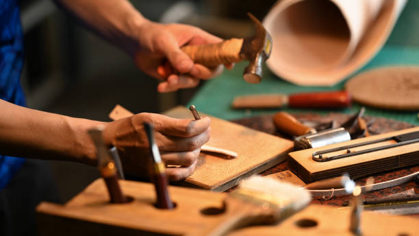 istock Closeup shot of craftsman working with leather and using craft tools at his workshop. Handmade concept 2161720541