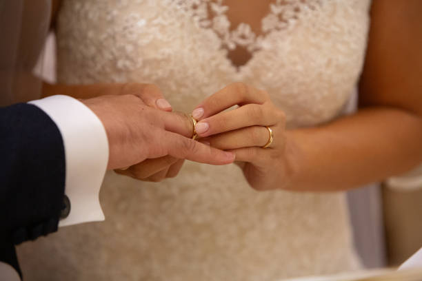 istock Bride putting wedding ring on groom's finger during ceremony 2161722017