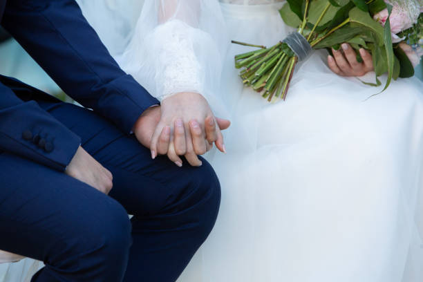 Groom and bride holding hands during wedding ceremony, romantic and intimate moment